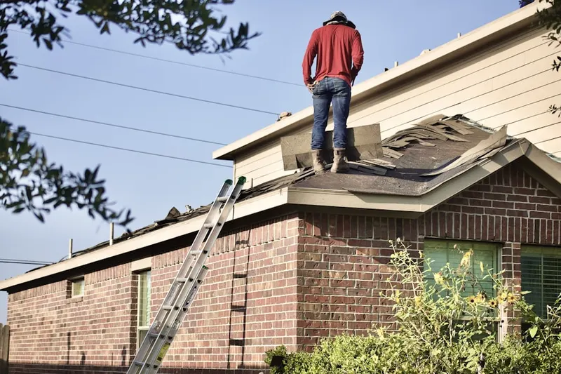 Professional roofer working on a residential roof in Fairview